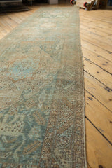 Distressed Heriz runner border, showing geometric patterns, muted teal and beige tones, even wear.