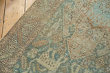 Distressed Heriz runner corner, muted seafoam green, beige motifs, and worn pile.