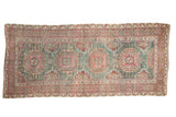 Distressed vintage Oushak runner rug with repeating gul medallions, mallard green, and dusty red.
