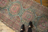 Distressed Oushak rug runner with faded gul medallions and abrashed green field.