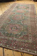 Distressed Oushak rug's raspberry red gul medallion with intricate geometric pattern.