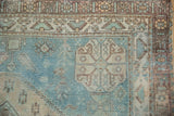 Distressed texture of aqua blue and sand geometric motifs on vintage Afshar rug.