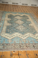 Geometric floral motifs on the aqua blue and ivory field of a distressed vintage Sirjan rug.