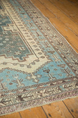 Distressed geometric border on a vintage Sirjan carpet with aqua blue and ivory.