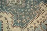 Distressed aqua blue field with geometric pinwheel motifs and antique ivory serrated contour.