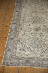 Distressed Hamadan runner displaying softened geometric field and border patterns in ivory and charcoal.