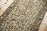 Distressed vintage Hamadan runner with worn geometric patterns and antique ivory, brown pile.