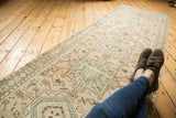 Distressed Karaja runner with faded geometric patterns and visible wear across knot heads.