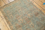 Distressed Borchalou rug's low pile texture with faded peachy blush and sky blue.