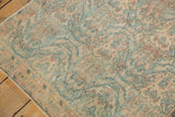 Distressed vintage Borchalou rug: low pile, knot heads, peachy blush, and sky blue hues.