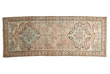 Distressed vintage Serab runner shows geometric medallions and a muted beige, blue, brown palette.