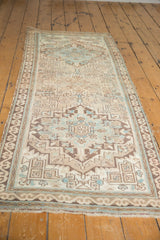 Distressed vintage Serab runner with muted rounded medallion, serrated leaves, and geometric borders.