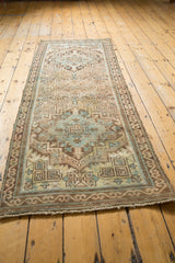 Distressed vintage Serab runner's end, with muted sandy beige and brown geometric border.