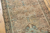 Distressed texture on muted sandy beige and blue geometric serrated leaf motifs.