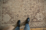 Distressed vintage Shiraz carpet with low pile geometric patterns in ivory and pale chocolate.
