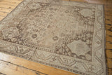 Distressed Shiraz carpet corner featuring geometric Abadeh style spandrels and neutral ivory, chocolate tones.