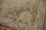Distressed vintage Shiraz rug corner showcasing Abadeh style geometric patterns in beige.