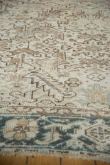 Vintage distressed Heriz rug detail with visible knot heads, beige geometric field, and teal border.