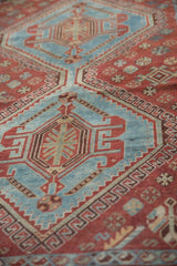 Aqua blue geometric rams horn medallion with germinating tree motif on distressed Qashqai rug.