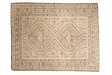 Vintage distressed Shiraz rug displays twin diamond medallions, geometric floral motifs in beige and brown.