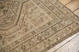 Corner of distressed vintage Shiraz rug showing muted geometric patterns and soft pile.