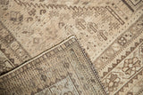 Distressed beige, sand, and brown geometric patterns with visible foundation of vintage Shiraz rug.