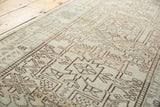 Angled view of vintage distressed Karaja runner, geometric motifs in faded ivory and coffee brown.