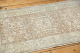 Distressed pile texture of a vintage Karaja rug showing muted geometric vinery in antique ivory and brown.