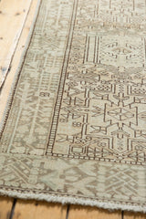 Close-up of the distressed vintage Karaja runner's geometric vinery in beige and brown.