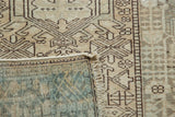Distressed coffee geometric pattern on the Karaja rug's pile and its woven slate gray reverse.