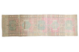 Distressed vintage Karaja runner rug with faded pastel pink and pale blue medallions.