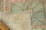 Distressed Karaja rug pile with geometric vinery, pale green, and exposed woven foundation.