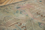 Faded geometric patterns and worn pile texture on a distressed vintage Serab rug.