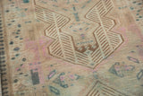 Finned geometric patterns on distressed Serab rug in antique ivory, pink, and dusty teal.