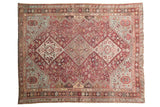 Vintage distressed Qashqai rug with a central geometric medallion in faded fuchsia, sky blue, and ivory.