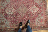 Harmonious geometric patterns on a distressed Qashqai rug in fuchsia, sky blue, and ivory tones.