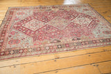 Full perspective view of a distressed Qashqai rug's geometric fuchsia and sky blue pattern.