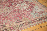 A distressed vintage Qashqai rug corner with fuchsia, sky blue, and ivory geometric details.