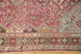 Intricate geometric borders in fuchsia, sky blue, and charcoal on a distressed vintage Qashqai rug.