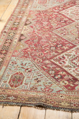 Angled view showing the even wear across the geometric patterns of a vintage Qashqai rug.
