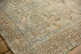 Distressed vintage Karaja rug corner, rectilinear motifs in sand, beige, and powder blue.
