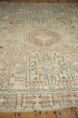Distressed Karaja rug's rectilinear patterns in muted ivory, sand, and powder blue.