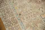 Distressed Karaja rug's geometric border, powder blue, pale gold, and faint foundation visible.