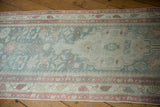 Distressed Malayer rug runner's worn field with faded floral cross sections and soft tones.