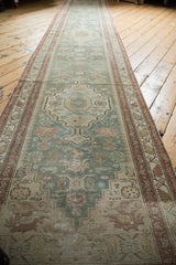Distressed Malayer runner: muted seafoam, ivory, faded floral medallions, visible worn pile.