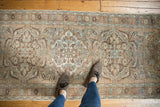 Vintage distressed Ahar runner featuring softened curvilinear floral medallions in muted beige and blue.