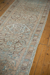 Distressed vintage Ahar runner's curvilinear patterns in beige, chocolate, and pale blue.