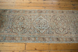 Distressed vintage Ahar runner featuring muted beige, brown, and blue floral medallions.