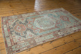 Distressed Malayer rug corner with geometric borders, faded peach and sea foam green.