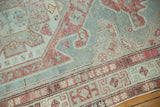 Faded pale blue and raspberry geometric patterns on a vintage distressed Malayer rug.
